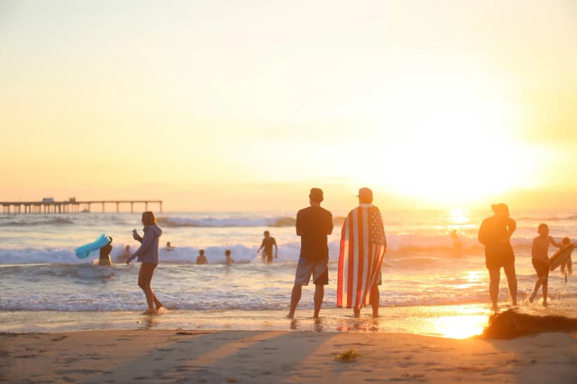 Personnes sur la plage de San Diego au coucher du soleil pendant un séjour linguistique aux États-Unis.